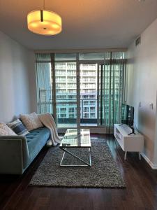 多伦多Lakeview Condo in Downtown with Free Parking.的带沙发和玻璃桌的客厅