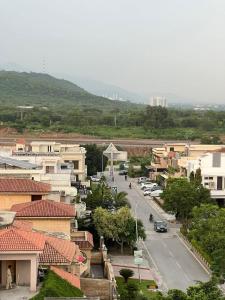 伊斯兰堡Balcony View/Aesthetic One bedroom Apartment的路边有街道和汽车的小城镇