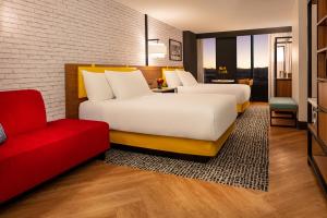 拉斯维加斯Pleasant Unit at New York New York Strip Las Vegas的配有红色沙发的酒店客房内的两张床
