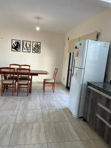 科尔多瓦Casa 3 dormitorios. - Barrio Valle Cercano的厨房配有桌子和白色冰箱。