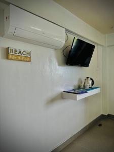 波尔多·格尼拉Playa Blanca Beach Resort的墙上有电视的房间