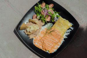 AtotonilcoAtotonilco Hotel & Club的黑盘食物,有鱼米和蔬菜