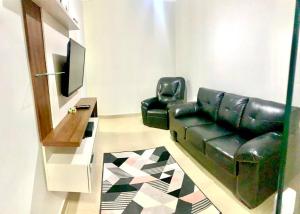 圣卡洛斯Recanto Algodão-Doce - Área de Lazer em São Carlos的客厅配有黑色真皮沙发和电视