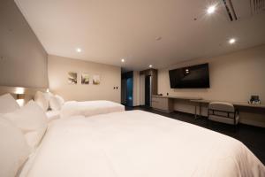 光州Hotel SUMMIT的卧室配有一张白色大床和一台平面电视。