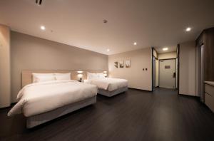 光州Hotel SUMMIT的一间卧室配有两张带白色枕头的床
