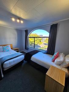 北帕默斯顿庄园汽车旅馆的酒店客房设有两张床和窗户。