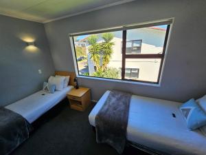 北帕默斯顿庄园汽车旅馆的酒店客房设有两张床和大窗户。