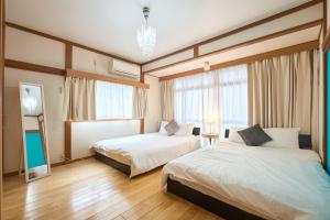 东京Shinjuku luxury house/107㎡/16P的酒店客房设有两张床和窗户。