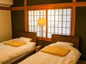 Ikeda1組限定　1棟貸切 「おとまり忠左衛門」　 グループや3世代旅行に最適　　　　的带窗户的客房内的两张床