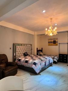 奥里萨巴San José的一间卧室配有一张床、一张沙发和一个吊灯。