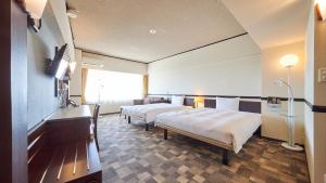 成田Toyoko Inn Narita Airport Honkan的酒店客房设有两张床和窗户。