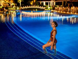 名户Oriental Hotel Okinawa Resort & Spa的夜间在游泳池的女人