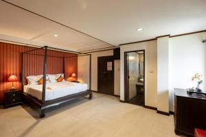 清迈Na Thapae Chiangmai Hotel的一间带大床的卧室和一间浴室