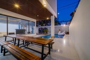 头顿Blue Sea Villa Vũng Tàu 5的一个带2个木长椅和游泳池的庭院