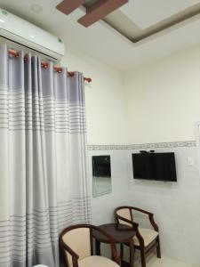 永熙Khách sạn Mộng An的一间设有两把椅子和窗帘的窗户的房间