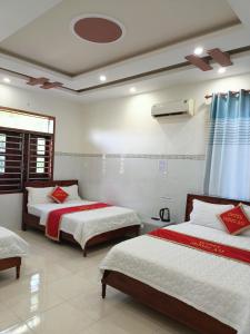 永熙Khách sạn Mộng An的一间卧室配有两张红色和白色床单