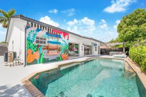 迈阿密Flamingo's Resort的一座带壁画的房子前的游泳池