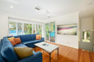麦夸里港菲林冲浪海滩别墅酒店的客厅配有蓝色的沙发和桌子