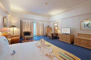 雅加达Sunlake Waterfront Resort & Convention的配有一张床和一张书桌的酒店客房