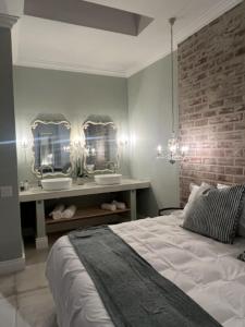 开普敦Two on Milner - OAK TREE COTTAGE - Stylish open-plan Guesthouse in Rondebosch的卧室配有一张床,墙上有两面镜子