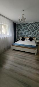 GiurgiuCasa Domnească的一间卧室配有一张床和一个吊灯