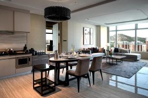 济南济南鲁能希尔顿酒店及公寓 的厨房以及带桌椅的起居室。