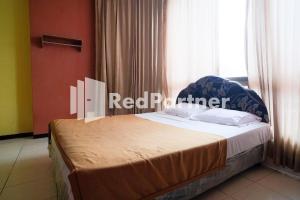 泗水RedDoorz at Sparkling Hotel Surabaya的一间带床的卧室,位于带窗户的房间内