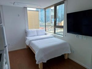 首尔318 Stay - Foreigners Only的一间小卧室,配有一张床和一台平面电视