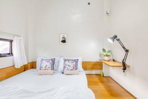 NgabeanTeras Sabin的一间卧室配有一张带白色床单和一盏灯的床。