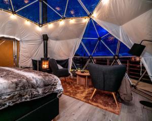 Sør-FronArctic Dome Gudbrandsdalen的圆顶帐篷内的卧室,配有一张床和椅子