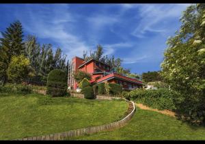 乌提Willow Hill by Nature Resorts的一座带庭院的山丘上的红色房子