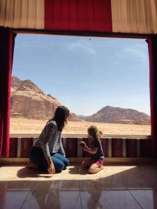 瓦迪拉姆Enad desert camp的坐在窗前的女人和孩子
