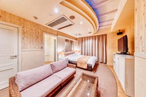 广岛HOTEL LITZ HIROSHIMA -Adult Only的酒店客房设有一张沙发和一张床