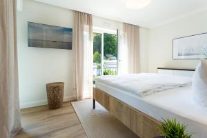 宾茨Villa Chloe "Beach and Ocean Binz"的白色的卧室设有一张大床和一个窗户