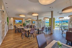 KirchrothBachhof Resort Hotel的用餐室设有桌椅和窗户。