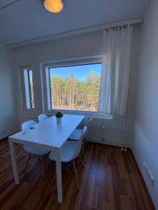 万塔Kotimaailma - Saunallinen kolmio lähellä lentokenttää的窗户客房内的白色桌椅