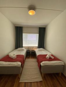 万塔Kotimaailma - Saunallinen kolmio lähellä lentokenttää的客房设有两张床和窗户。