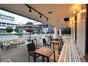 大阪Hotel Shin-Imamiya - Vacation STAY 36320v的一个带桌椅和遮阳伞的庭院