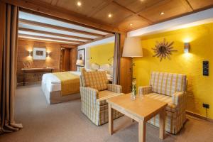 奥夫特尔施旺Sonnenalp Resort的酒店客房带一张床、一张桌子和椅子