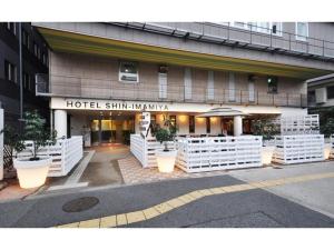 大阪Hotel Shin-Imamiya - Vacation STAY 36320v的大楼前有白色围栏的酒店入口
