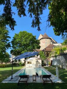 波朗特吕Manoir de la Côte-Dieu的一个带2个长椅和遮阳伞的游泳池
