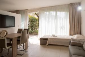 维琪奥港Résidence Domaine De Caranella公寓 的酒店客房配有一张床、一张书桌和一台电视。