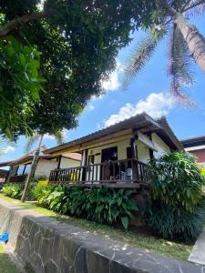 MungguKubu Di Omo Villas的一座黄色的小房子,拥有门廊和树木