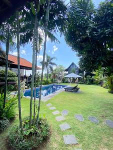MungguKubu Di Omo Villas的一个带游泳池和棕榈树的度假庭院