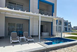 马萨阿拉姆Casa Blue Resort的房屋设有1个带椅子和游泳池的庭院