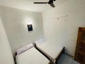 玛纳多迪Bethel inn的小房间设有两张床和吊扇