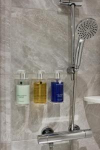 托基Lincombe Hall Hotel & Spa - Just for Adults的淋浴间玻璃架上的三瓶除臭剂
