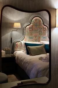 托基Lincombe Hall Hotel & Spa - Just for Adults的镜子反射着卧室,卧室配有床头板和床