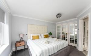 佩恩顿Loveliest Homes Paignton - Casa Marina - 3 bed, 2 bathroom house, balcony, parking的卧室配有一张带黄色枕头的大型白色床。