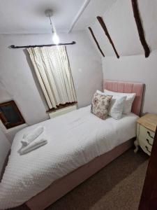 亨登Two Bedroom Grade ll Cottage At AZ Luxury Stays Honey Horsefield With WiFi And Free Parking的卧室配有白色床和粉红色床头板